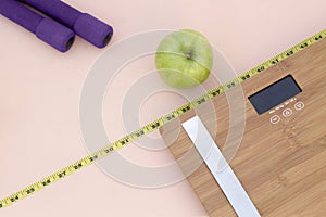 Still Life photography with a green apple, weight tape measure and a scale photo