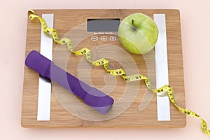 Still Life photography with a green apple, weight tape measure and a scale photo