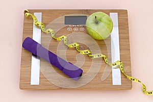 Still Life photography with a green apple, weight tape measure and a scale photo