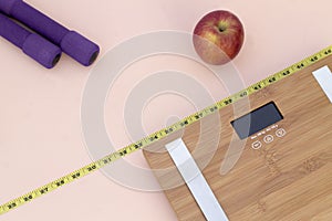 Still Life photography with a red apple, weight tape measure and a scale