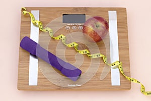 Still Life photography with a red apple, weight tape measure and a scale photo