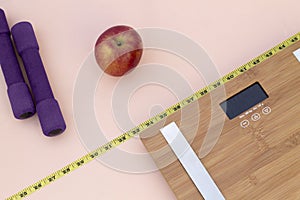 Still Life photography with a red apple, weight tape measure and a scale photo