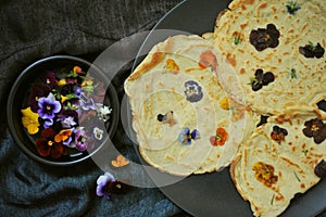Still life photography of slow living concept with edible flowers crepes as a healthy and happy snack