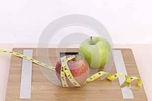 Still Life photography with two apples, tape mesaure and a scale photo