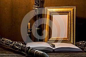 Still life of picture frame on wooden table with clarinet