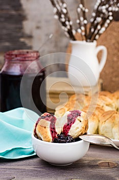 Still life with pieces of monkey bread and berries jam on a wooden table