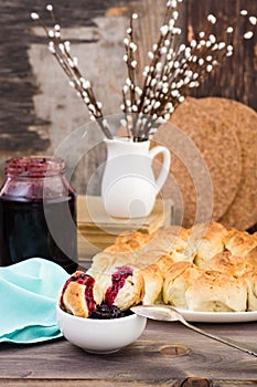 Still life with pieces of monkey bread and berries jam on a wooden table