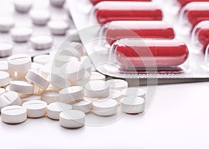 Still life with pile of round pills or tablets, antidepressants or painkillers with space for text. Red capsules in blister pack