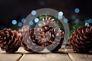 Still life with pine cones and fir tree branch on rustic wooden table. Christmas greeting card.