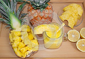 Still life. Pineapple juice, cocktails with fresh pineapple for breakfast in the morning on a wooden tray. Detox.