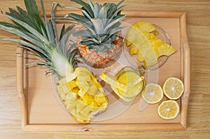 Still life. Pineapple juice, cocktails with fresh pineapple for breakfast in the morning on a wooden tray. Detox. For health and f