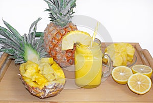 Still life. Pineapple juice, cocktails with fresh pineapple for breakfast in the morning on a wooden tray, on a white background.