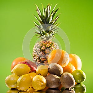 Still life pineapple and various fruits on green background, square shot