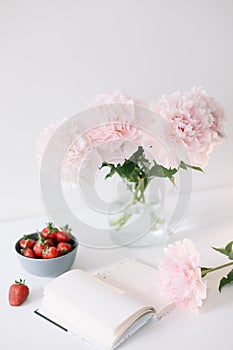 Still life with pink peony flowers and open  book. Summer concept.  fresh flowers at home, cozy interior
