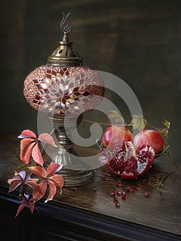 Still life with pomegranates and decorative lamp