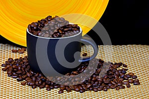Coffee cup filled with coffee beans on dark background