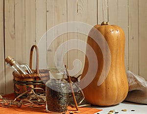 Still life with pumpkin lagenaria, linen napkin and glass jar of seeds, horizontal with space