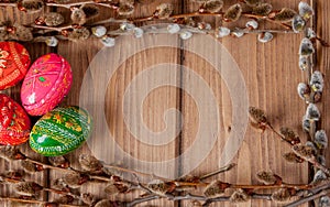 Still life with Pysanka, decorated Easter eggs, dry willow branches on black wooden background, top view, copy space