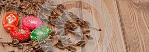 Still life with Pysanka, decorated Easter eggs, dry willow branches on black wooden background, top view, copy space