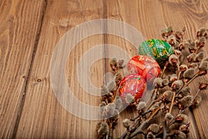 Still life with Pysanka, decorated Easter eggs, dry willow branches on black wooden background, top view, copy space