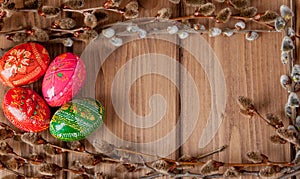 Still life with Pysanka, decorated Easter eggs, dry willow branches on black wooden background, top view, copy space