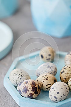 Still life. Quail eggs in a ceramic plate on a textured background. Rustic. Easter celebration concept