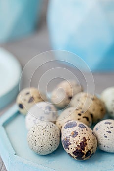 Still life. Quail eggs in a ceramic plate on a textured background. Rustic. Easter celebration concept