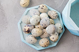 Still life. Quail eggs in a ceramic plate on a textured background. Rustic. Easter celebration concept