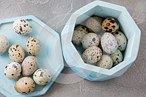 Still life. Quail eggs in a ceramic plate on a textured background. Rustic. Easter celebration concept