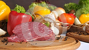 Still life with raw pork meat and fresh vegetables