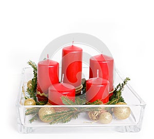 Still life with red candles, golden balls and ribbons, fir branches in glassware on a white background, Christmas