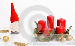 Still life with red candles, golden balls and ribbons, fir branches in glassware on a white background, Christmas