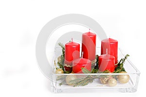 Still life with red candles, golden balls and ribbons, fir branches in glassware on a white background, Christmas