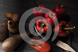 STILL LIFE OF RED PEPPERS ON A RUSTIC WOODEN TABLE