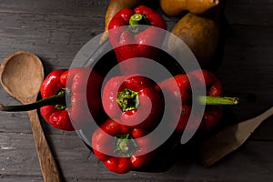 STILL LIFE OF RED PEPPERS ON A RUSTIC WOODEN TABLE