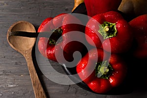 STILL LIFE OF RED PEPPERS ON A RUSTIC WOODEN TABLE