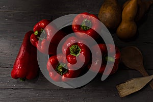 STILL LIFE OF RED PEPPERS ON A RUSTIC WOODEN TABLE