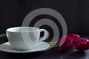 Still life with red tulips. bouquet of tulips with white coffee cup
