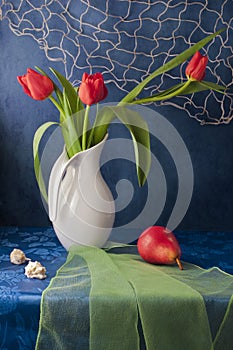 Still life with red tulips and red pear