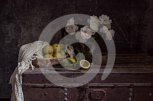 Still life with roses on a old box and lemons close-up