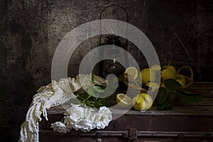 Still life with roses on a old box and lemons close-up