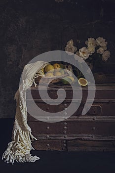 Still life with roses on a old box and lemons close-up