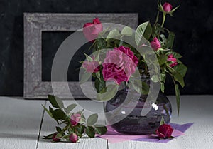 Still life with roses in a purple bottle 