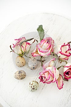 Still life with roses. Quail eggs on a wooden stand. Rustic. Easter celebration concept