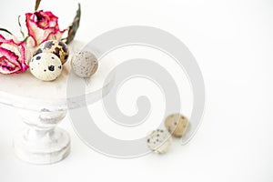 Still life with roses. Quail eggs on a wooden stand. Rustic. Easter celebration concept