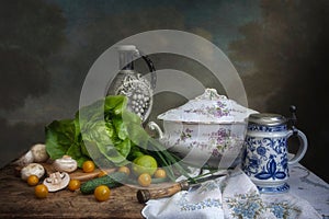 Still life in a rustic kitchen with vegetables and a basket of pansies