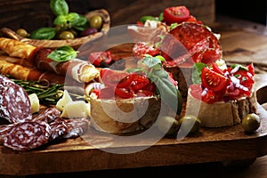 Still life in a rustic style. Grapes on a wooden table with a bottle of wine and meat and cheese. Antipasto and red wine