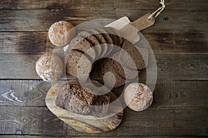 Still life with rye bread with sesame seeds and buns white bread on a wooden rustic background, top view, flat lay