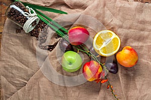 Still life on sacking background: apple, peaches, orance, plums photo