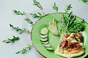 A still-life with scrambled eggs, fresh cucumbers and fried potatoes with meat. photo
